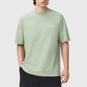 Model wearing sage green AllSaints crew neck t-shirt with small chest logo print, styled with black trousers