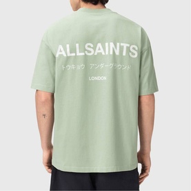 Model wearing AllSaints mint green oversized T-shirt, back view showing logo and Japanese script print with London text.