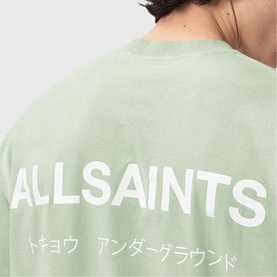 Model wearing AllSaints mint green crew neck T-shirt, back view showing bold white logo and Japanese text print