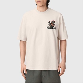 Model wearing All Saints Cacti Oversized Graphic Logo T-Shirt in Dusk White with snake and cactus print, styled with khaki trousers.