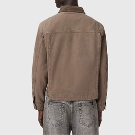 Model wearing All Saints Korey Canvas Jacket in Mire Brown, rear view, styled with light wash distressed jeans.
