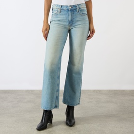 Model wearing Mother straight-leg jeans in Daydreamer light blue denim with frayed hem, styled with black ankle boots