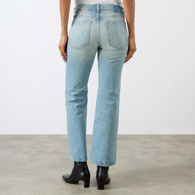 Model wearing Mother straight jeans in Daydreamer light blue wash, rear view, styled with black ankle boots