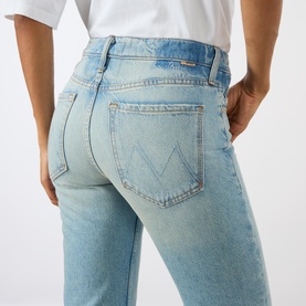 Model wearing Mother straight-leg jeans in Daydreamer light blue denim, rear view showing signature M-stitched back pockets