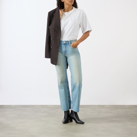Model wearing Mother straight jeans in Daydreamer light blue denim, styled with a white tee and dark blazer, paired with black heeled boots.