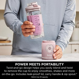 Ninja Blast Max Cordless Portable Blender in pink, shown being twisted off its base, with smoothie inside clear cup with measurement markings