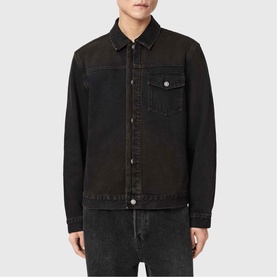 Model wearing All Saints Roth Denim Jacket in overdyed brown, with button fastenings, chest pocket and collar, styled with grey denim jeans.
