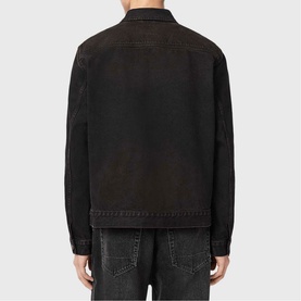 Model wearing All Saints Roth Denim Jacket in overdyed brown, back view, with collar and long sleeves, styled with dark denim jeans.