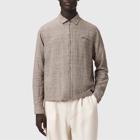 Model wearing All Saints Keal Check Jacket in sediment brown, linen-viscose blend with zip fastening, styled with cream trousers.