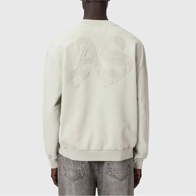 Model wearing light grey crew neck sweatshirt with tonal embroidered AS logo on back, styled with grey denim jeans