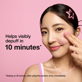 Model with Dr Jart mask applied under eye, demonstrating depuffing effect, pink background with text overlay.