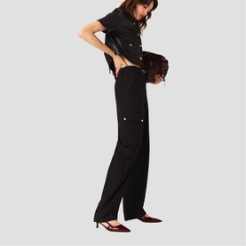 Model wearing Maje red wide-leg cargo trousers with black cropped jacket, styled with burgundy bag and red pointed-toe heels