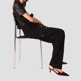 Model wearing Maje Womens French Dress in black with snap-button detail, styled with dark red slingback kitten heel mules.