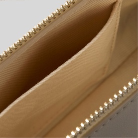 Claude Pierlot clear wallet interior detail showing gold-tone zip, crystal embellishment trim, and beige fabric lining