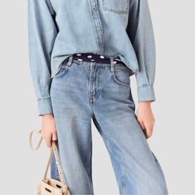 Maje navy dots print belt worn at waist over light blue denim jeans, styled with chambray shirt and small woven bag
