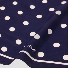 Maje navy blue scarf with white polka dot print and white border edge, fabric close-up showing brand logo
