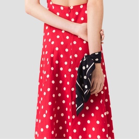 Model wearing Maje navy dots print dress, styled with a matching navy and white polka dot scarf accessory