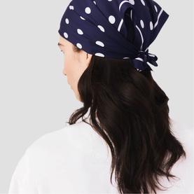 Model with Maje navy dots print headscarf tied at back, worn with white top