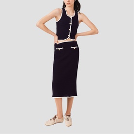 Model wearing Maje Womens French Dress in navy with white trim, styled as co-ord vest top and midi skirt set, with beige trainers.