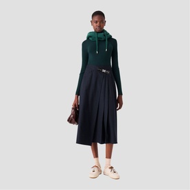 Model wearing Maje Womens French Dress in multi, styled with green hooded top, white loafers, and carrying a small burgundy bag.