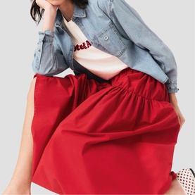Model wearing Maje Womens French Dress in red voluminous midi skirt style, styled with denim shirt and graphic tee