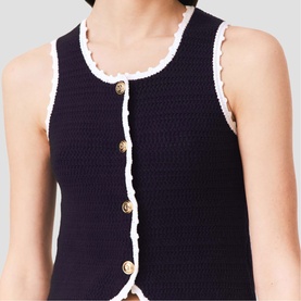 Model wearing Maje navy knit vest with white scallop trim and gold button detail front fastening