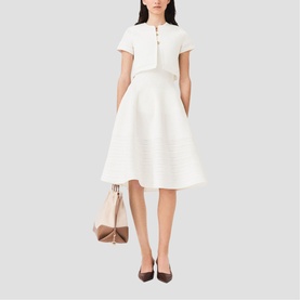 Model wearing Maje metallic white fit-and-flare midi dress with short sleeves and button detail, styled with nude bag and brown heels