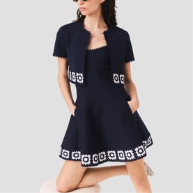Model wearing Maje navy mini dress with white crochet floral trim, styled with matching navy cropped cardigan jacket