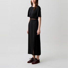 Model wearing Claude Pierlot Lace Slit Dress in black, midi length, satin effect with lace trim detail, styled with burgundy lace-up shoes
