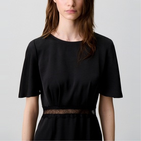 Model wearing Claude Pierlot Lace Slit Dress in black, showing satin-effect fabric, short flutter sleeves, round neck, and sheer lace insert at waist.