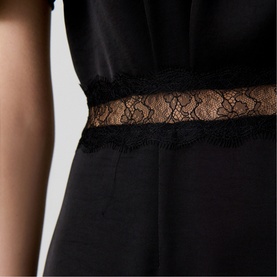 Model wearing Claude Pierlot Lace Slit Dress in black, close-up of sheer lace waist panel detail on satin-effect fabric
