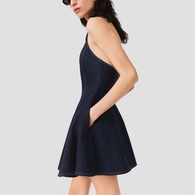 Model wearing Maje Womens French Dress in dark navy denim, sleeveless fit-and-flare silhouette with side pockets, side view