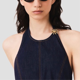 Model wearing Maje Womens French Dress in dark denim with contrast stitching and gold sunflower brooch detail, styled with black sunglasses.