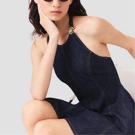 Model wearing Maje Womens French Dress in dark denim, halterneck style with gold floral detail, styled with black sunglasses