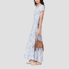 Model wearing Maje sky blue large floral print maxi dress with cap sleeves, styled with tan crossbody bag and beige shoes