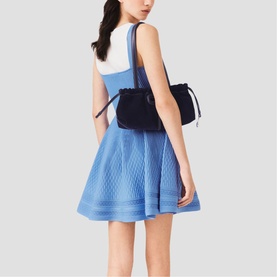 Model wearing Maje Womens French Dress in blue, rear view, styled with a black drawstring backpack