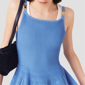 Model wearing Maje Womens French Dress in blue ribbed knit with white trim and gold hardware, styled with a black shoulder bag