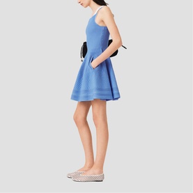 Model wearing Maje Womens French Dress in blue, flared skater silhouette with spaghetti straps, styled with black bag and white polka-dot flats
