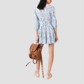Model wearing Maje sky blue large floral print mini dress with three-quarter sleeves, styled with tan backpack and beige heeled sandals