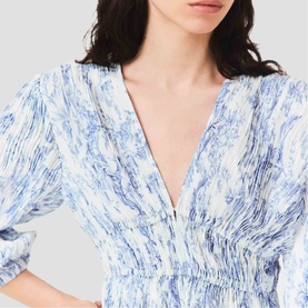 Model wearing Maje Womens French Dress in sky blue large floral print, close-up of V-neckline with zip detail and elasticated waist