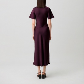 Model wearing Claude Pierlot Womens French Dress in Dark Dahlia, back view, fluted sleeves, midi length, styled with black platform heels.