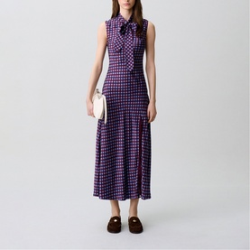 Model wearing Claude Pierlot Womens French Dress in burgundy print, sleeveless midi length with bow neck detail, styled with brown loafers and white