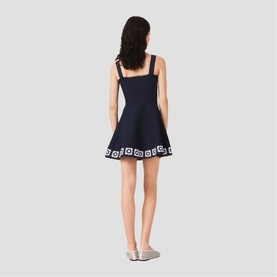 Model wearing Maje Womens French Dress in navy with white graphic hem detail, square neckline, flared skirt, back view