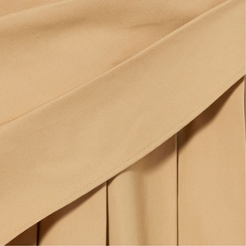 Claude Pierlot Pleated Drape Skirt in clear beige cotton, showing midi-length silhouette with flat pleats and integrated scarf detail at side.