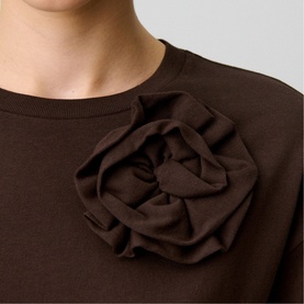 Model wearing Claude Pierlot brown sweatshirt with oversized corsage rose appliqu&eacute; detail at chest