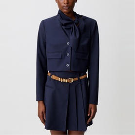Model wearing Claude Pierlot Cropped Single-Breasted Blazer in blue with removable scarf collar, styled with matching blue mini skirt and tan belt.