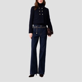 Model wearing Maje navy cropped double-breasted jacket and wide-leg dark jeans, styled with a brown clutch bag and black heels