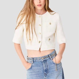 Model wearing cream cropped short-sleeve jacket with gold buttons, styled with light wash jeans