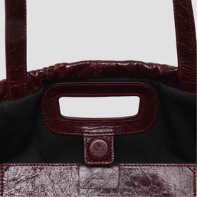 Maje bag in gold crinkled leather, close-up showing structured top handle and branded press-stud detail