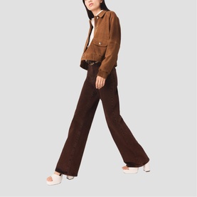 Model wearing Maje wide-leg brown corduroy trousers and a tan suede cropped jacket, styled with white mule heels